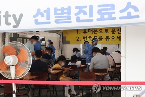 ソウル市内の新型コロナウイルス検査所で順番を待つ人々＝２５日、ソウル（聯合ニュース）