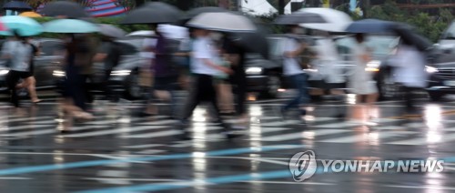 우산을 쓴 시민들이 횡단보도를 걷고 있다. [연합뉴스 자료사진]