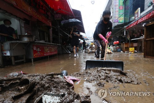 폭우 피해 복구하는 전통시장 상인