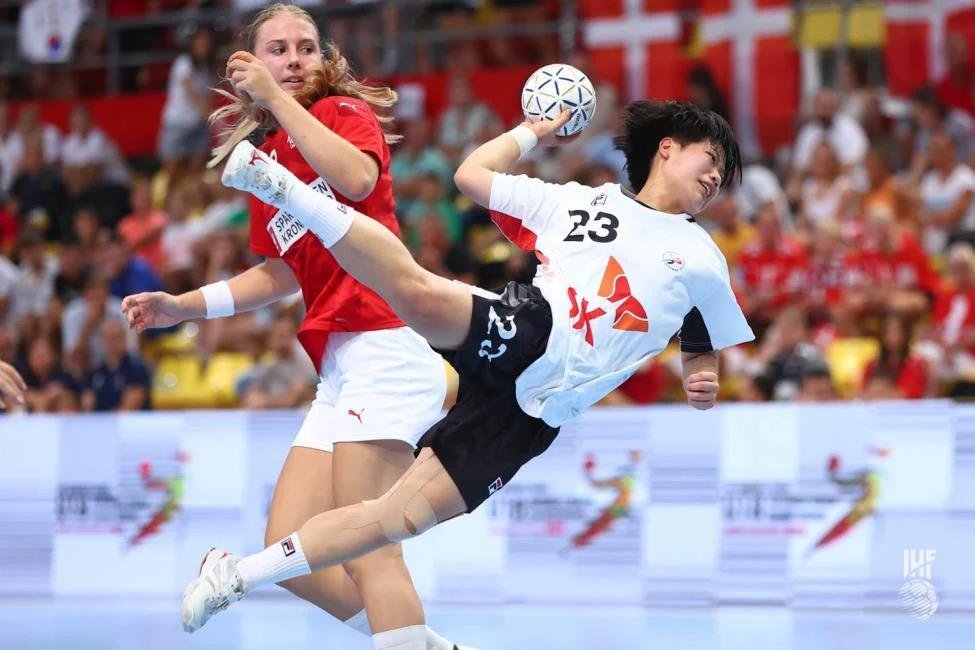 Kim Min-seo of South Korea (R) takes a shot against Denmark during the final of the International Handball Federation (IHF) Women's Youth World Championship at Boris Trajkovski Sports Center in Skopje, North Macedonia, on Aug. 10, 2022, in this photo provided by the IHF. (PHOTO NOT FOR SALE) (Yonhap)