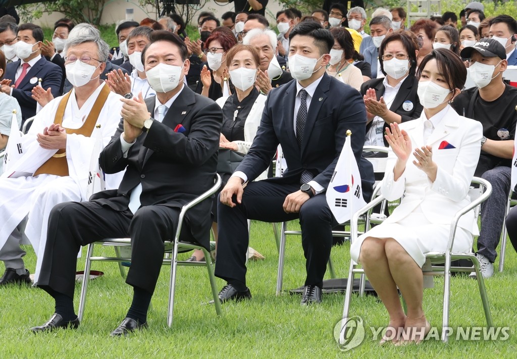 El presidente, Yoon Suk-yeol (izda., frente), y la primera dama, Kim Keon-hee (dcha., frente), aplauden durante una ceremonia para conmemorar el 77º Día de la Liberación Nacional, el 15 de agosto de 2022, en el jardín de la oficina presidencial, en Seúl.