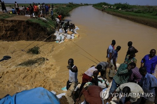 홍수로 파괴된 운하 복구하는 수단 시민들