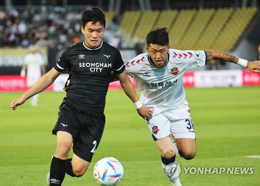 Goo Bon-cheol of Seongnam FC (L) and Shin Se-gye of Suwon FC battle for the ball during the clubs' K League 1 match at Tancheon Stadium in Seongnam, just south of Seoul, on Aug. 28, 2022. (Yonhap)