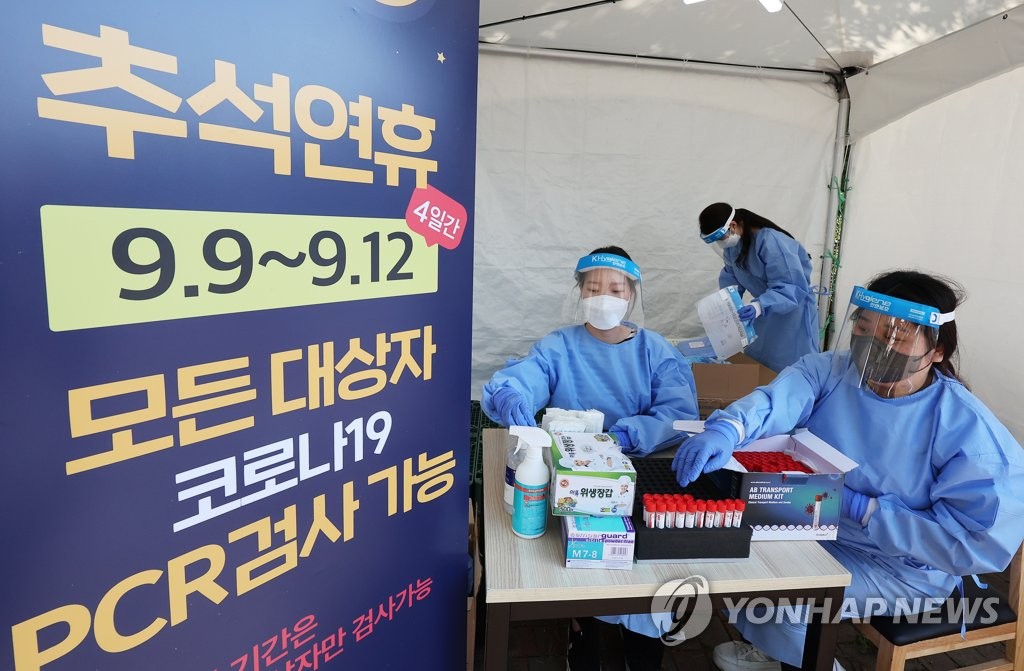 En la fotografía de archivo, tomada el 7 de septiembre de 2022, unas trabajadoras médicas colocan kits de prueba del coronavirus sobre una mesa en una cabina de pruebas instalada en un área de descanso cerca de una autopista en Yongin, a 40 kilómetros al sur de Seúl.