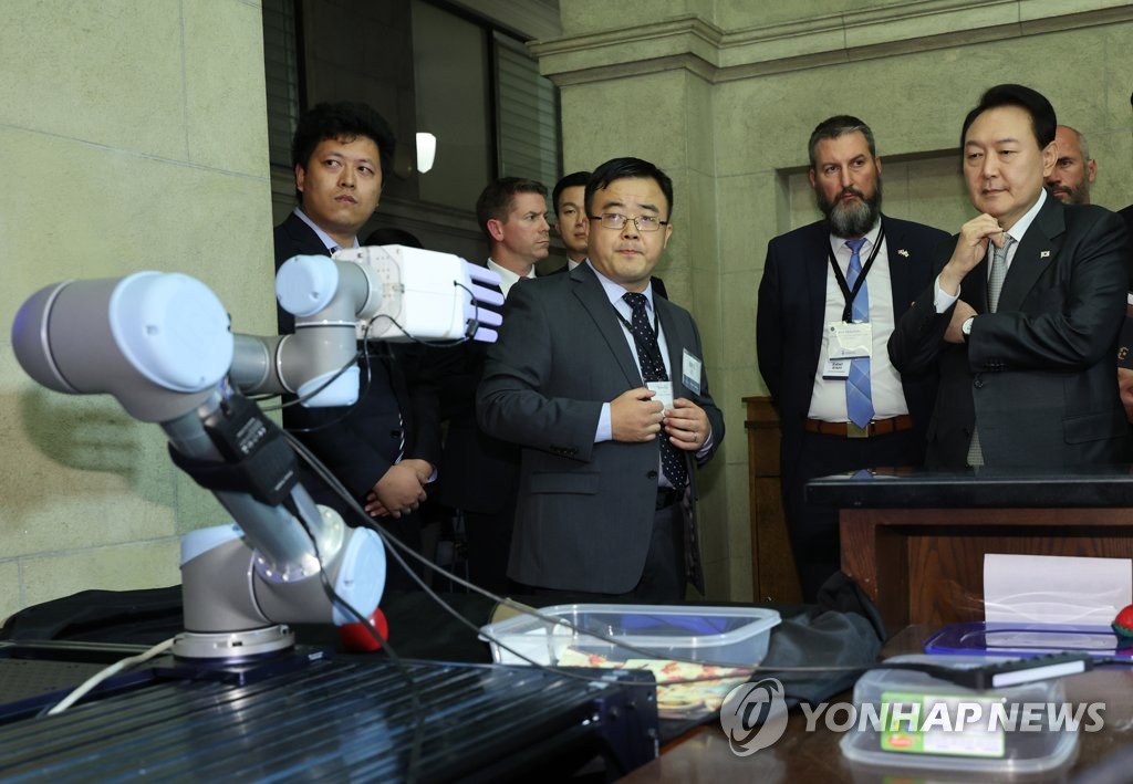 トロント大で研究中のロボットの実演を見る尹大統領（右端）＝２２日、トロント（聯合ニュース）