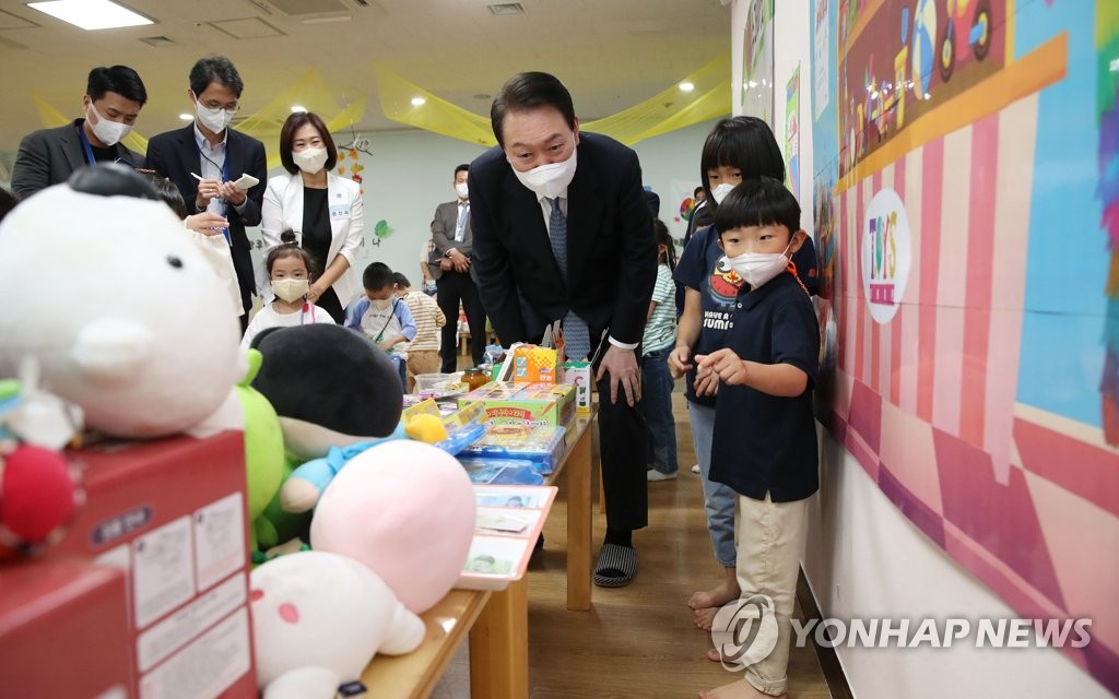 El presidente, Yoon suk-yeol (centro, frente), se reúne con los niños, el 27 de septiembre de 2022, en una guardería de la ciudad central de Sejong.