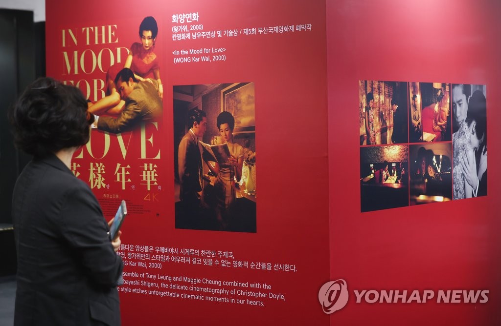 A visitor looks at the poster of Hong Kong actor Tony Leung Chiu-wai's special exhibit at the Busan Cinema Center in Busan on Oct. 6, 2022. (Yonhap) 