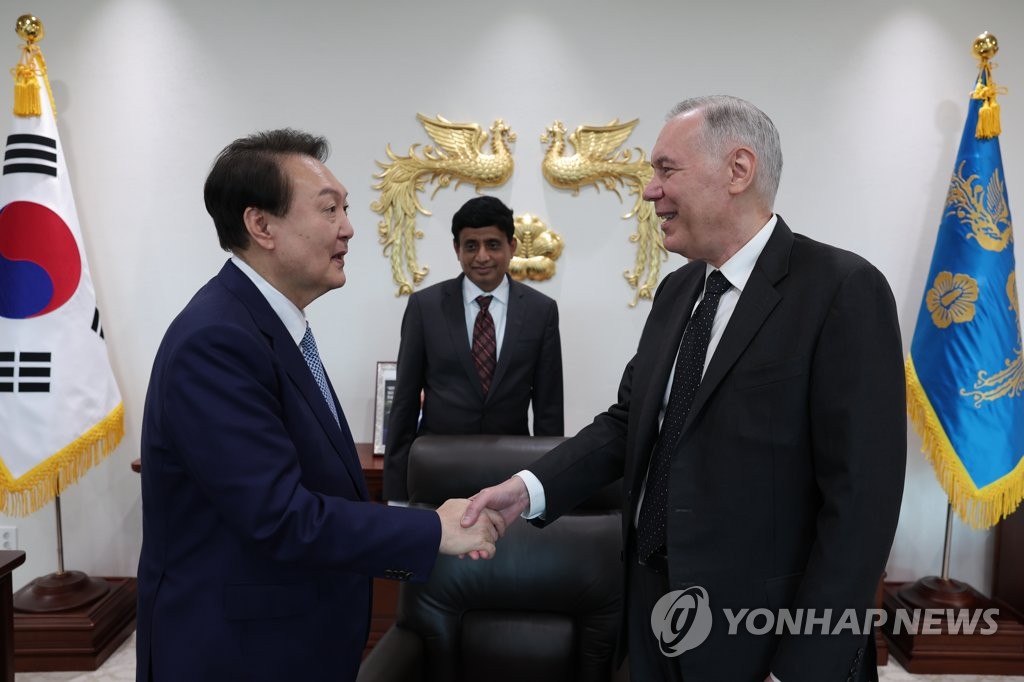 South Korean President Yoon Suk-yeol (L) shakes hands with Gary Dickerson, president and CEO of Applied Materials Inc., the world's largest supplier of chip-producing machinery, during their meeting at the presidential office in Seoul on Oct. 7, 2022, in this photo provided by the office. (PHOTO NOT FOR SALE) (Yonhap)