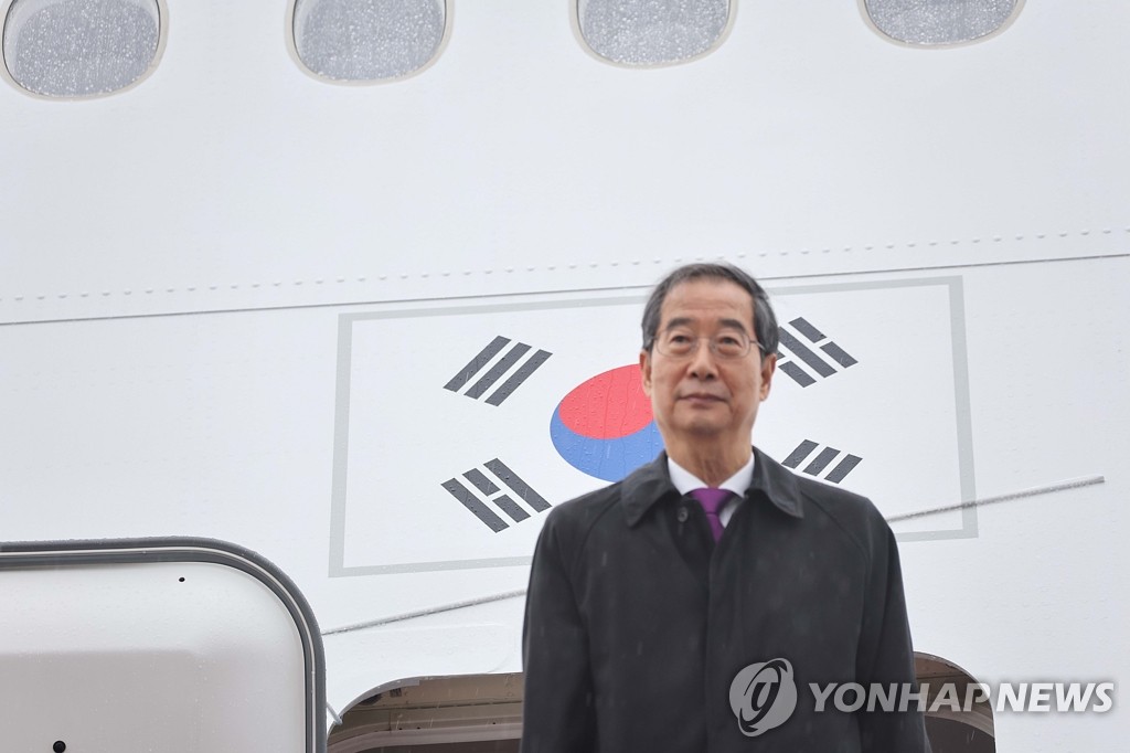 El primer ministro surcoreano, Han Duck-soo, posa ante las cámaras, el 9 de octubre de 2022, mientras aborda el avión que lo llevará a una gira por tres países latinoamericanos -Chile, Uruguay y Argentina-, desde la base área Aeropuerto de Seúl, en Seongnam, al sur de la capital surcoreana.