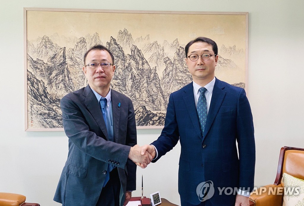 This photo provided by the South Korean foreign ministry on Oct. 12, 2022, shows Kim Gunn (R), the ministry's special representative for Korean Peninsula peace and security affairs, shaking hands with his Japanese counterpart, Takehiro Funakoshi, at the South Korean foreign ministry in Seoul. (PHOTO NOT FOR SALE) (Yonhap)