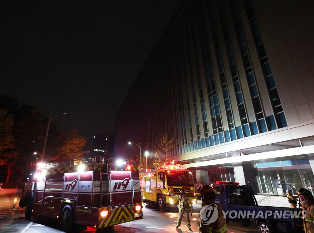 Firefighters work in front of a building of SK C&C in Pangyo, just south of Seoul, on Oct. 15, 2022, after a fire broke out there. (Yonhap)