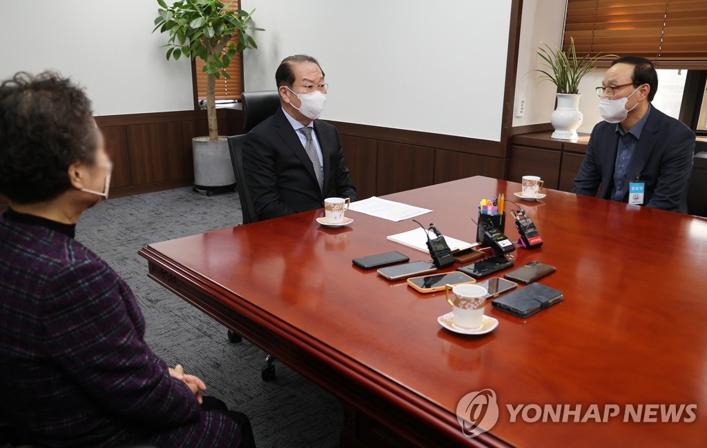 北朝鮮に拘束された人の家族と面会する韓国の権寧世・統一部長官（中央）＝２１日、ソウル（聯合ニュース）