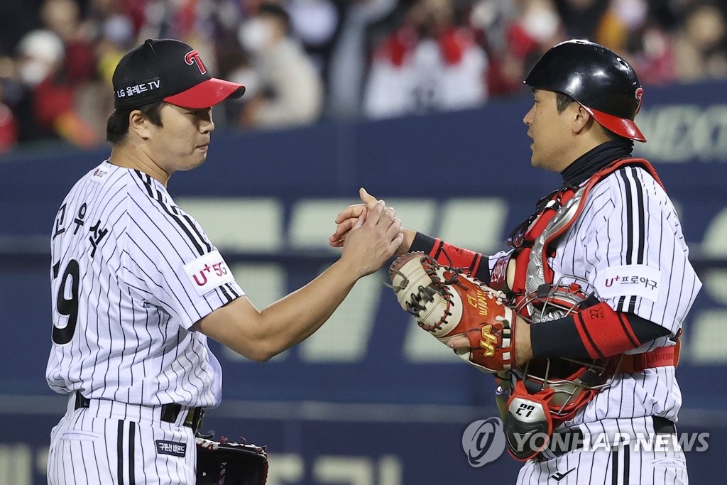 LG Twins closer Go Woo-suk (L) and catcher Yoo Kang-nam celebrate their team's 6-3 victory over the Kiwoom Heroes in Game 1 of the second round in the Korea Baseball Organization postseason at Jamsil Baseball Stadium in Seoul on Oct. 24, 2022. (Yonhap)