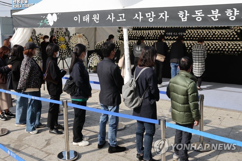 People stand in line to pay tribute on Oct. 31, 2022, at a joint memorial altar for the victims of a crowd crush in Seoul's Itaewon district near the scene of the accident that left at least 156, including 26 foreigners, killed during Halloween festivities two days ago. (Pool photo) (Yonhap)
