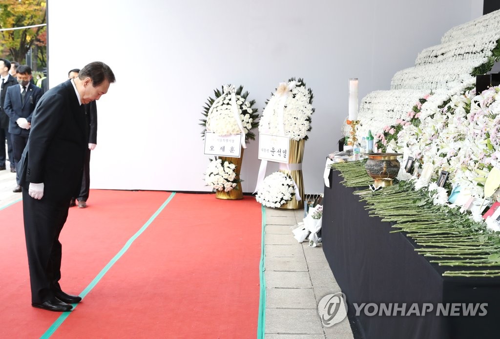 President Yoon Suk-yeol bows his head in silent tribute to the victims of the Halloween crowd crush at a mourning altar in front of City Hall in Seoul on Nov. 3, 2022. (Pool photo) (Yonhap)