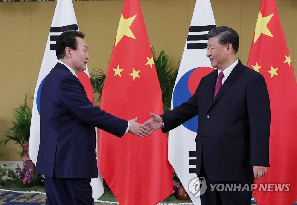 会談前に握手する尹錫悦（ユン・ソクヨル）大統領（左）と習近平国家主席＝１５日、バリ島（聯合ニュース）