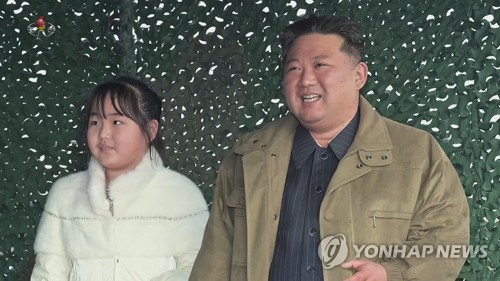 North Korean leader Kim Jong-un (R) stands next to his daughter to watch the launch of a Hwasong-17 intercontinental ballistic missile on Nov. 18, 2022, in this photo captured from the North's Korean Central Television on Nov. 20. It marks her first public appearance in state media. (For Use Only in the Republic of Korea. No Redistribution) (Yonhap)