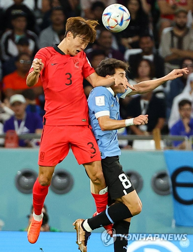 Kim Jin-su of South Korea (L) heads the ball ahead of Facundo Pellistri of Uruguay during the countries' Group H match at the FIFA World Cup at Education City Stadium in Al Rayyan, west of Doha, on Nov. 24, 2022. (Yonhap)