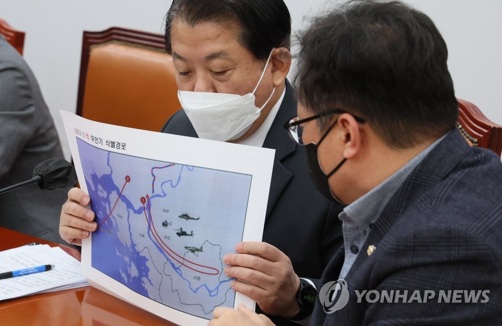 En esta foto de archivo del 29 de diciembre de 2022, el representante Kim Byung-joo (izquierda) del principal opositor Partido Demócrata en la Asamblea Nacional en el oeste de Seúl sostiene una imagen de un mapa que muestra las rutas de vuelo identificadas de los drones norcoreanos que invadieron en el espacio aéreo de Corea del Sur.  (Yonhap) 