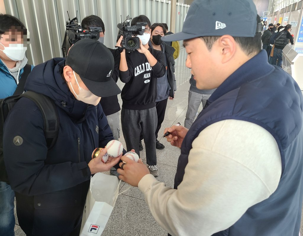 In this file photo from Jan. 8, 2023, Pittsburgh Pirates first baseman Choi Ji-man (R) signs an autograph for a fan at Incheon International Airport, west of Seoul. (Yonhap)