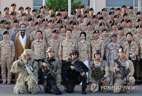 El presidente surcoreano, Yoon Suk Yeol (quinto por la izda., segunda fila.), y la primera dama, Kim Keon Hee (cuarta por la dcha., segunda fila), posan para una fotografía grupal durante una reunión con los soldados de la unidad militar surcoreana Akh, celebrada, el 15 de enero de 2023 (hora local), en Abu Dabi, los Emiratos Árabes Unidos.