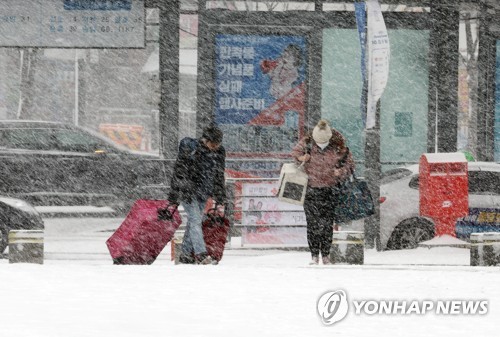 Travelers head to a bus station in the southwestern city of Gwangju to return home on Jan. 24, 2023, the last day of the four-day Lunar New Year holiday, amid heavy snowfall. (Yonhap)
