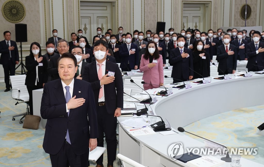 President Yoon Suk Yeol (front) salutes the national flag during the unification and interior ministries' joint reports for the year 2023 at Cheong Wa Dae, the former presidential office, in Seoul on Jan. 27, 2023. (Yonhap)