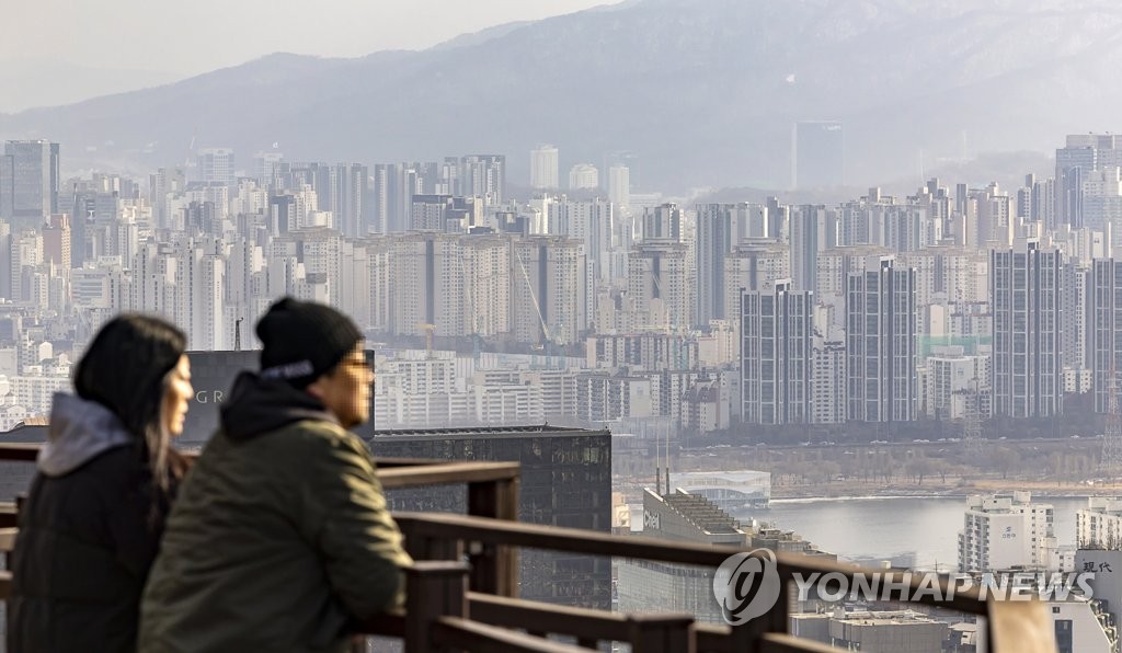 People enjoy a view of central Seoul from Mount Nam on Jan. 29, 2023. (Yonhap)