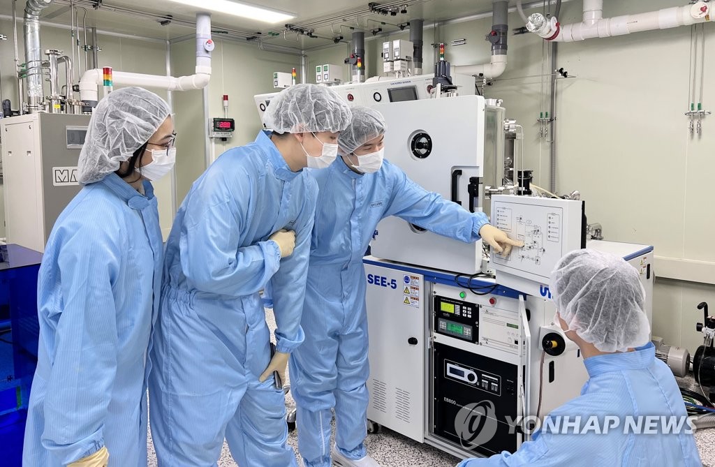A demonstration of a semiconductor manufacturing process is under way at a university. (Yonhap)
