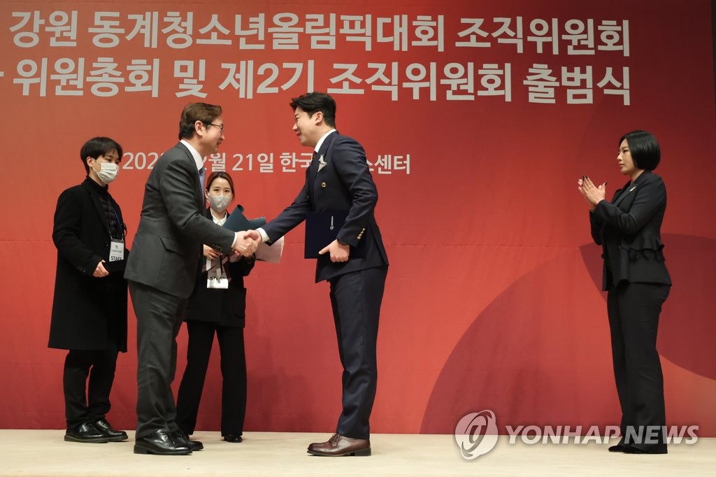 South Korean Olympic shooting champion Jin Jong-oh (C) shakes hands with Sports Minister Park Bo-gyoon after being named a co-head of the organizing committee for the 2024 Gangwon Winter Youth Olympics in a ceremony in Seoul on Feb. 21, 2023. (Yonhap)