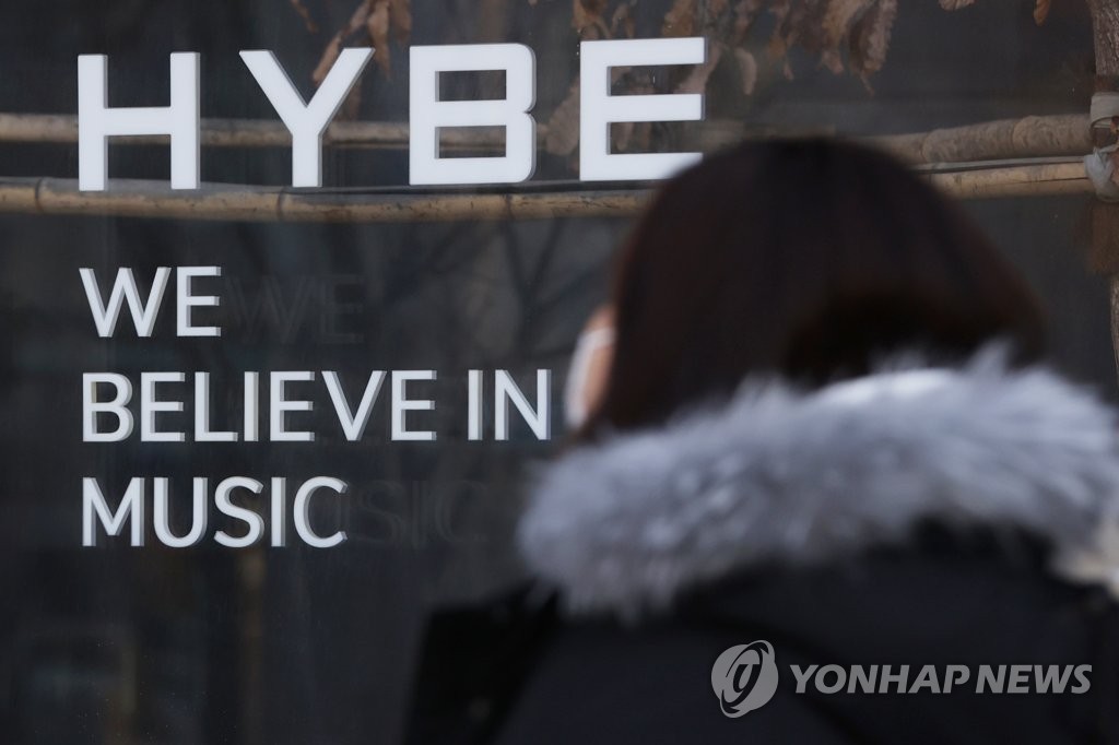 Une piétonne passe devant le bâtiment du géant de la K-pop Hybe à Séoul, le 21 février 2023.