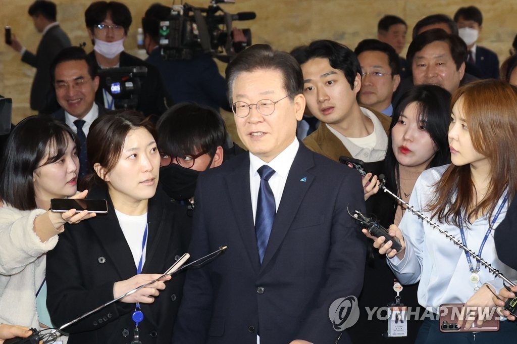 Democratic Party Chairman Lee Jae-myung is surrounded by reporters as he heads to the main hall of the National Assembly building in Seoul on Feb. 27, 2023, ahead of a vote on a motion seeking parliamentary consent to his arrest over corruption charges. (Yonhap)
