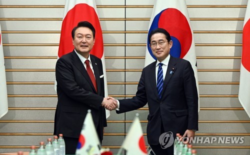 １６日の韓日首脳会談で握手を交わす尹大統領（左）と岸田首相＝（聯合ニュース）