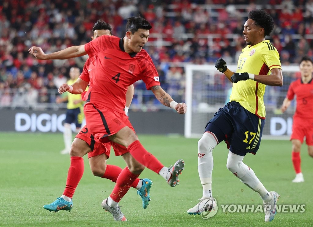 Kim Min-jae of South Korea (L) clears the ball past Johan Mojica of Colombia during the teams' friendly football match at Munsu Football Stadium in Ulsan, 305 kilometers southeast of Seoul, on March 24, 2023. (Yonhap)