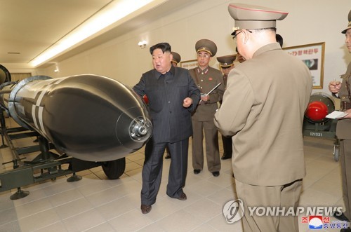 La foto, publicada, el 28 de marzo de 2023, por la KCNA, muestra al líder norcoreano, Kim Jong-un (izda., de negro), guiando un proyecto de militarización nuclear del país. (Uso exclusivo dentro de Corea del Sur. Prohibida su distribución parcial o total)