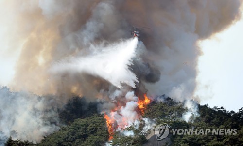 消火活動を行うヘリコプター＝２日、ソウル（聯合ニュース）