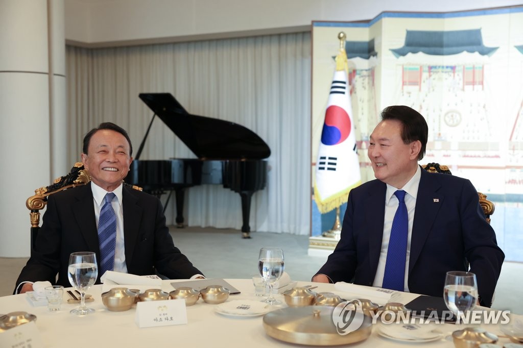 １１日午後、夕食を取りながら話を交わす尹大統領（右）と麻生氏（大統領室提供）＝（聯合ニュース）≪転載・転用禁止≫