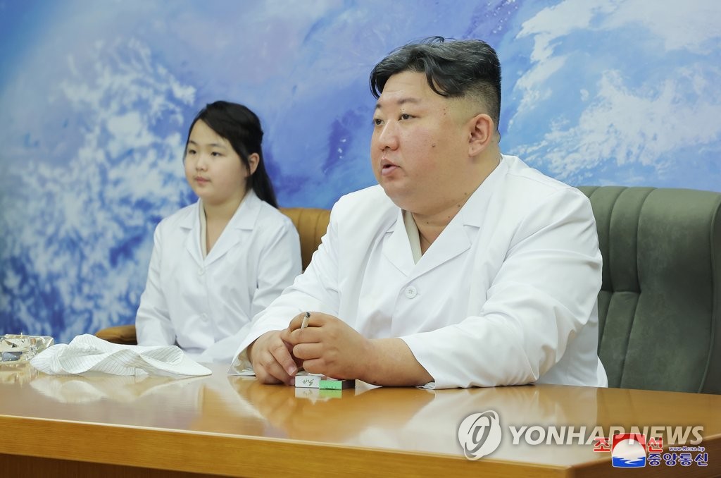 North Korean leader Kim Jong-un (R), along with his daughter Ju-ae, is pictured as he meets with members of the Non-permanent Satellite Launch Preparatory Committee in Pyongyang on May 16, 2023, to inspect the country's first military reconnaissance satellite, in this photo released by the North's official Korean Central News Agency. (For Use Only in the Republic of Korea. No Redistribution) (Yonhap)