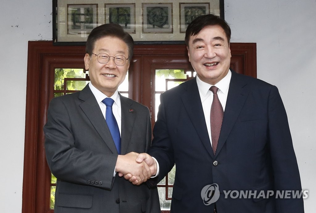 Lee Jae-myung (L), leader of South Korea's main opposition Democratic Party, shakes hands with China's Ambassador to Seoul Xing Haiming at the latter's residence in central Seoul on June 8, 2023. (Pool photo) (Yonhap)