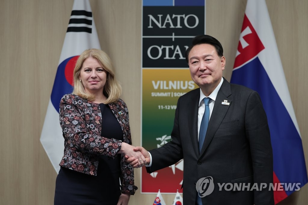 Juhokórejský prezident Yoon Suk-yeol (R) si podáva ruku so slovenskou prezidentkou Zuzanou Kaputovou počas rokovaní na okraj summitu Organizácie Severoatlantickej zmluvy v litovskom Vilniuse, 12. júla 2023.  (Fotka bazéna) (Yonhap)