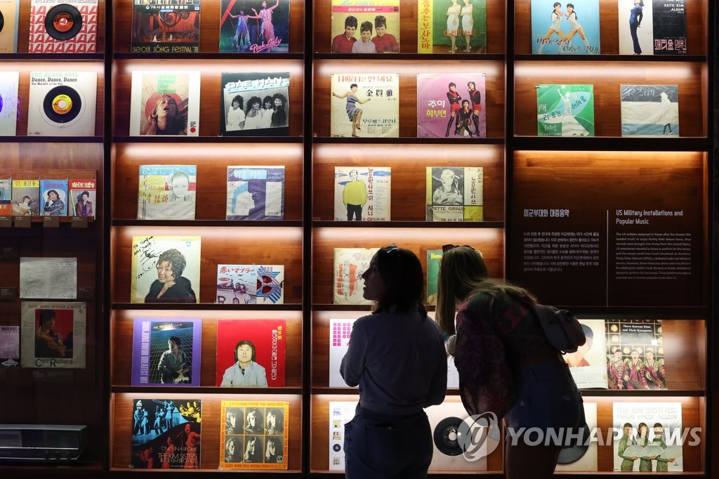 Visitors look at LP records on display at an exhibition, titled "The Pop Culture We Loved, and Rise of the Korean Wave," at the National Museum of Korean Contemporary History in Seoul on July 20, 2023. (Yonhap)