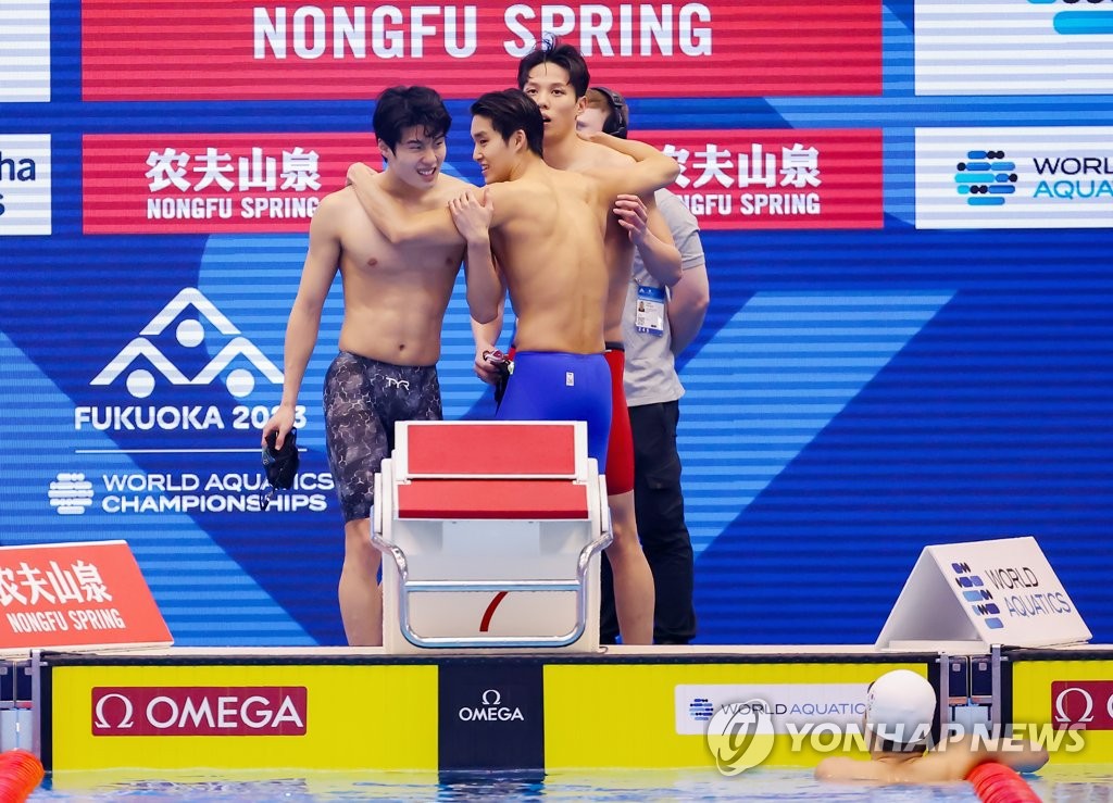 South Korean swimmers Hwang Sun-woo, Kim Woo-min and Yang Jae-hoon (L to R) celebrate after teammate Lee Ho-joon (in water) completed the final leg of the men's 4x200-meter freestyle relay for the national record time of 7:04.07 in the final at the World Aquatics Championships at Marine Messe Fukuoka Hall A in Fukuoka, Japan, on July 28, 2023. (Yonhap)