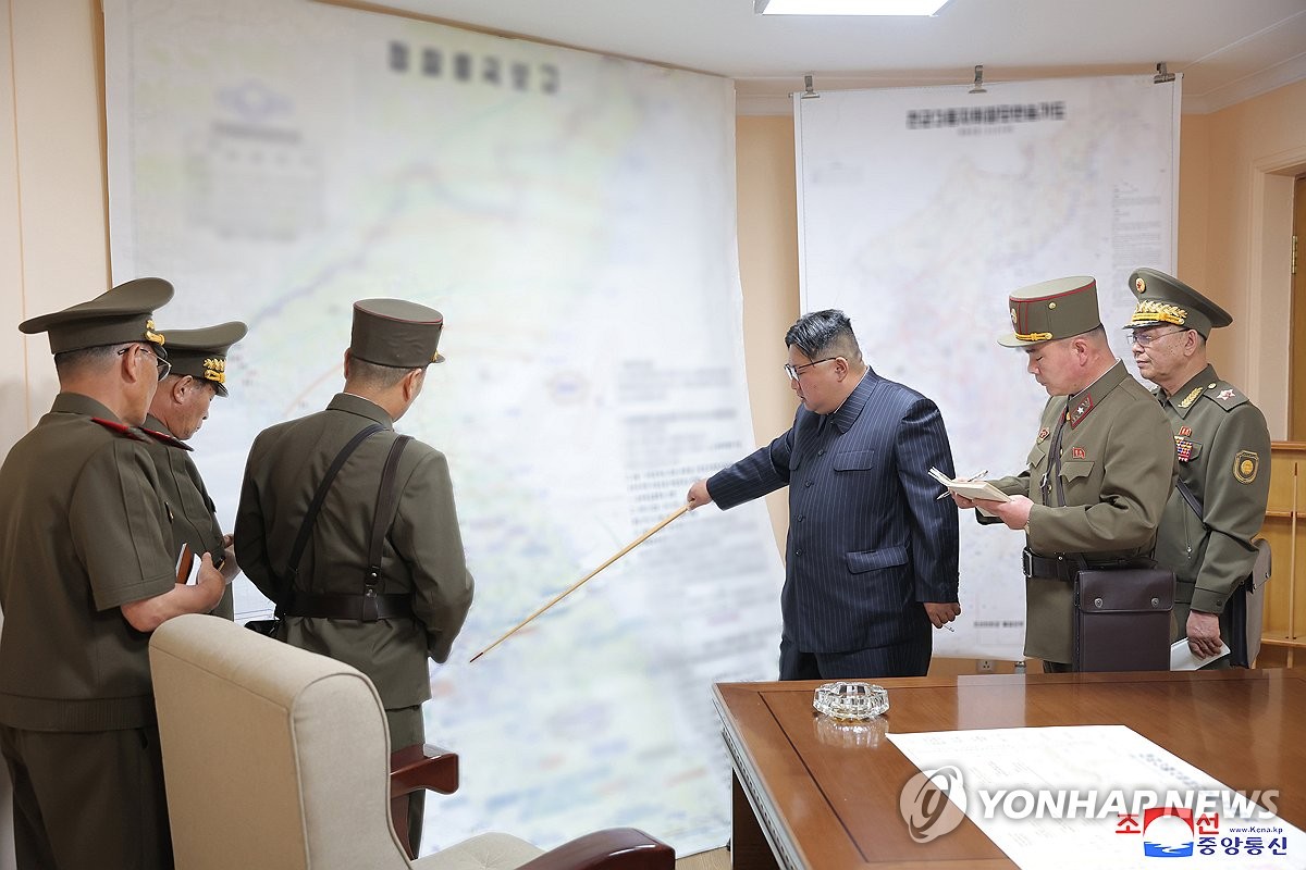 This photo, carried by North Korea's Korean Central News Agency on Aug. 31, 2023, shows the North's leader, Kim Jong-un (3rd from R), pointing at a South Korean region with a baton during a visit to the training command post of the General Staff of the North Korean army on Aug. 29. (For Use Only in the Republic of Korea. No Redistribution) (Yonhap)