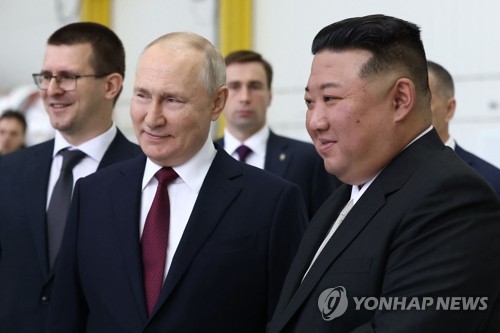 This AFP photo shows North Korean leader Kim Jong-un (R) and Russian President Vladimir Putin (C) smiling during their meeting at the Vostochny Cosmodrome space center in Russia's Amur region on Sept. 13, 2023. (Yonhap)