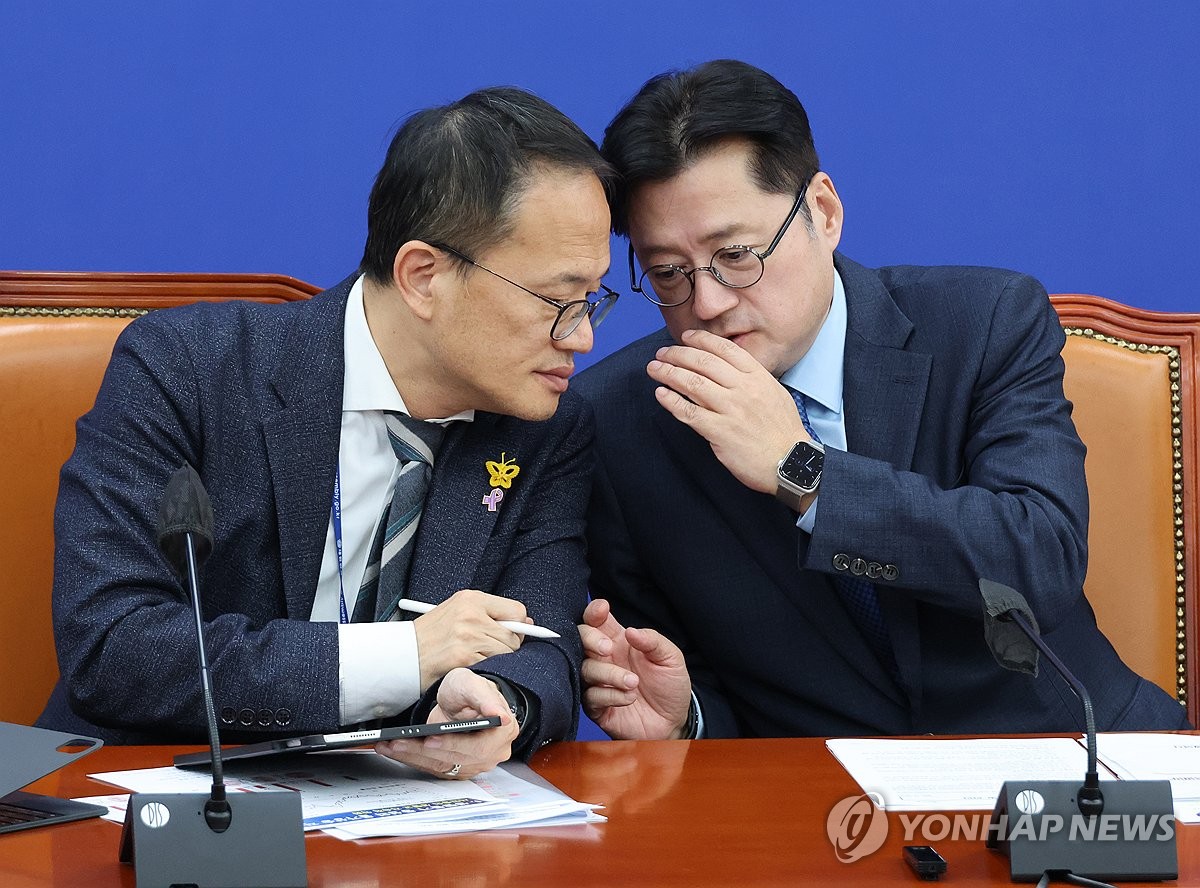 Rep. Hong Ihk-pyo (R), the floor leader of the main opposition Democratic Party, whispers to Rep. Park Ju-min at a policy meeting at the National Assembly in Seoul on Nov. 9, 2023. (Yonhap)