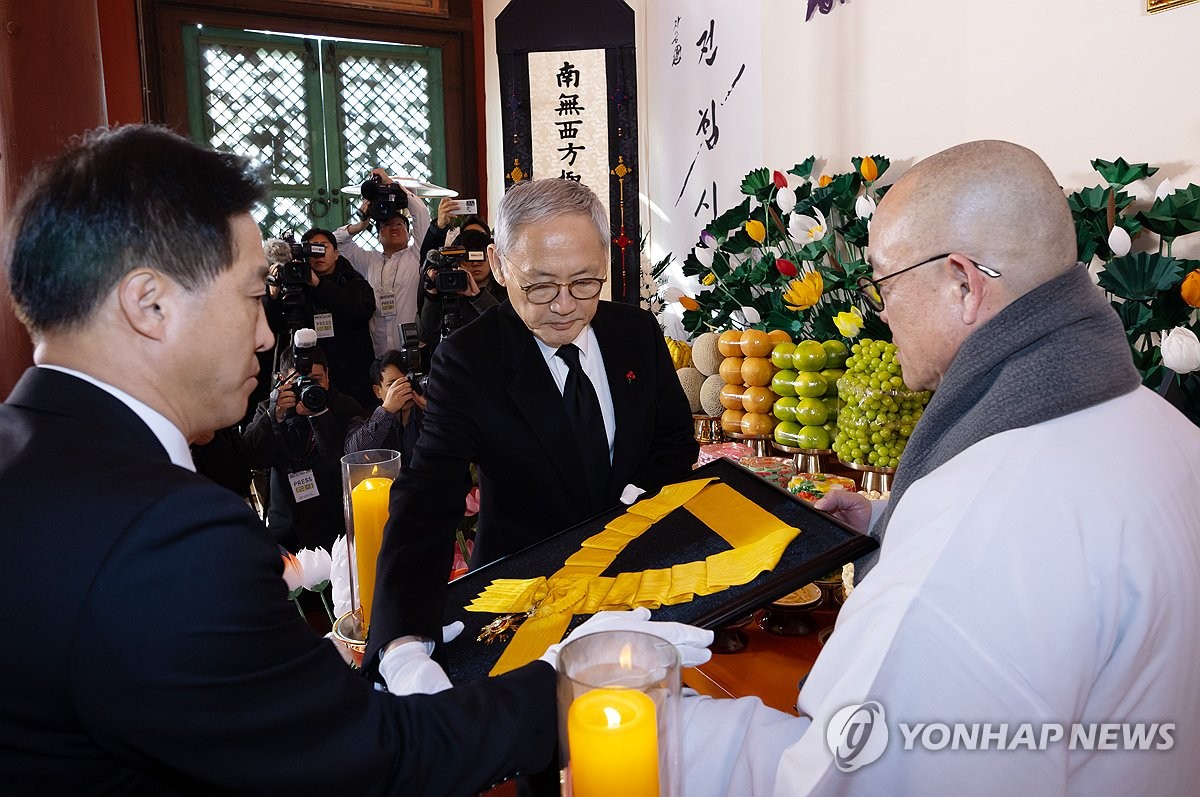 유인촌 문화체육관광부 장관이 2일 서울 종로구 조계사 대웅전에 마련된 전 조계종 총무원장 고(故) 자승스님 분향소에 정부 국민훈장 무궁화장을 추서하고 있다. 오른쪽은 대한불교조계종 제2교구본사교구장인 용주사 주지 성효 스님. / 연합뉴스