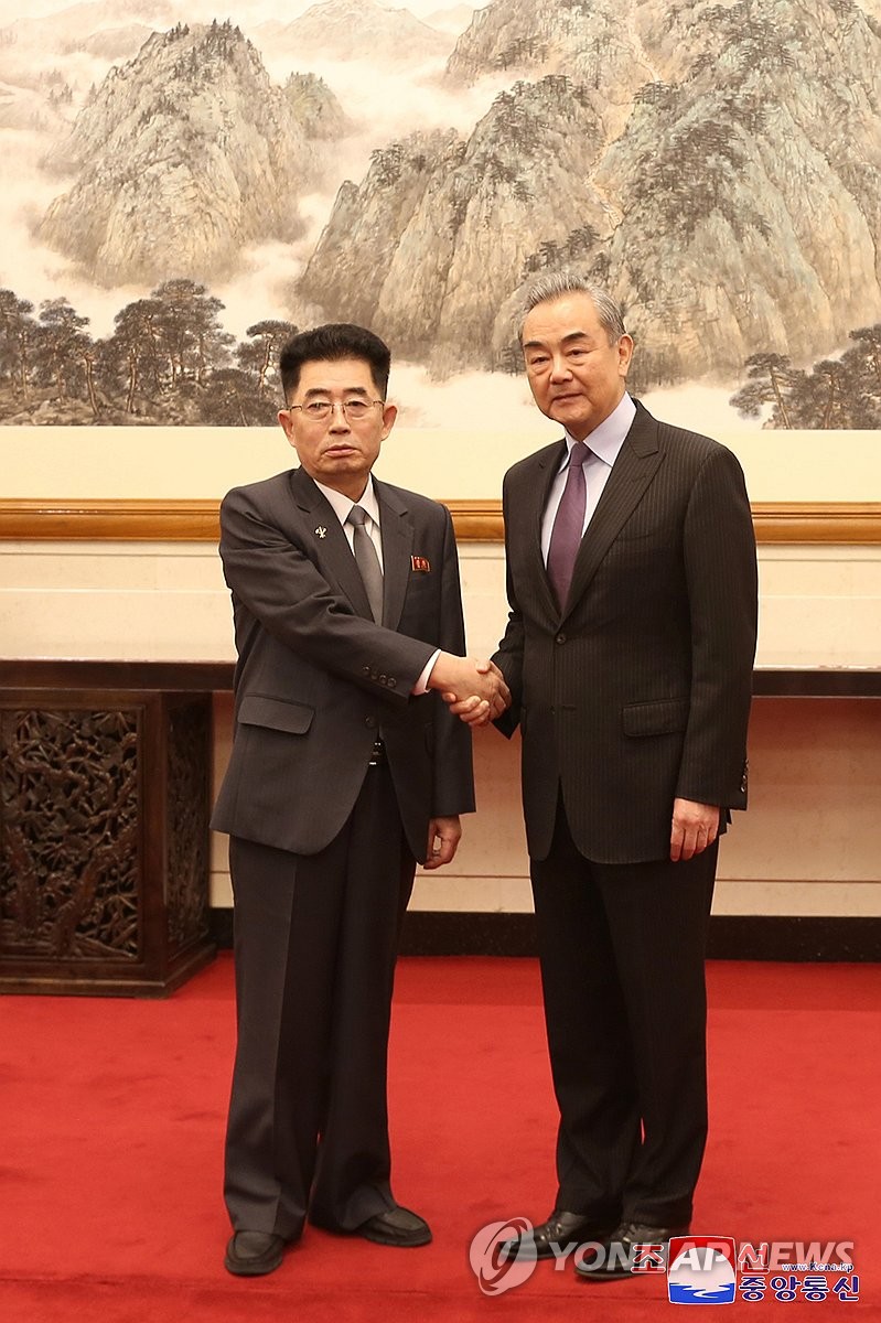 Kim Song-nam (L), director of the international department at the Workers' Party of North Korea, and Chinese Foreign Minister Wang Yi shake hands during their meeting in Beijing on March 23, 2024, in this photo carried by the North's Korean Central News Agency two days later. (For Use Only in the Republic of Korea. No Redistribution) (Yonhap)
