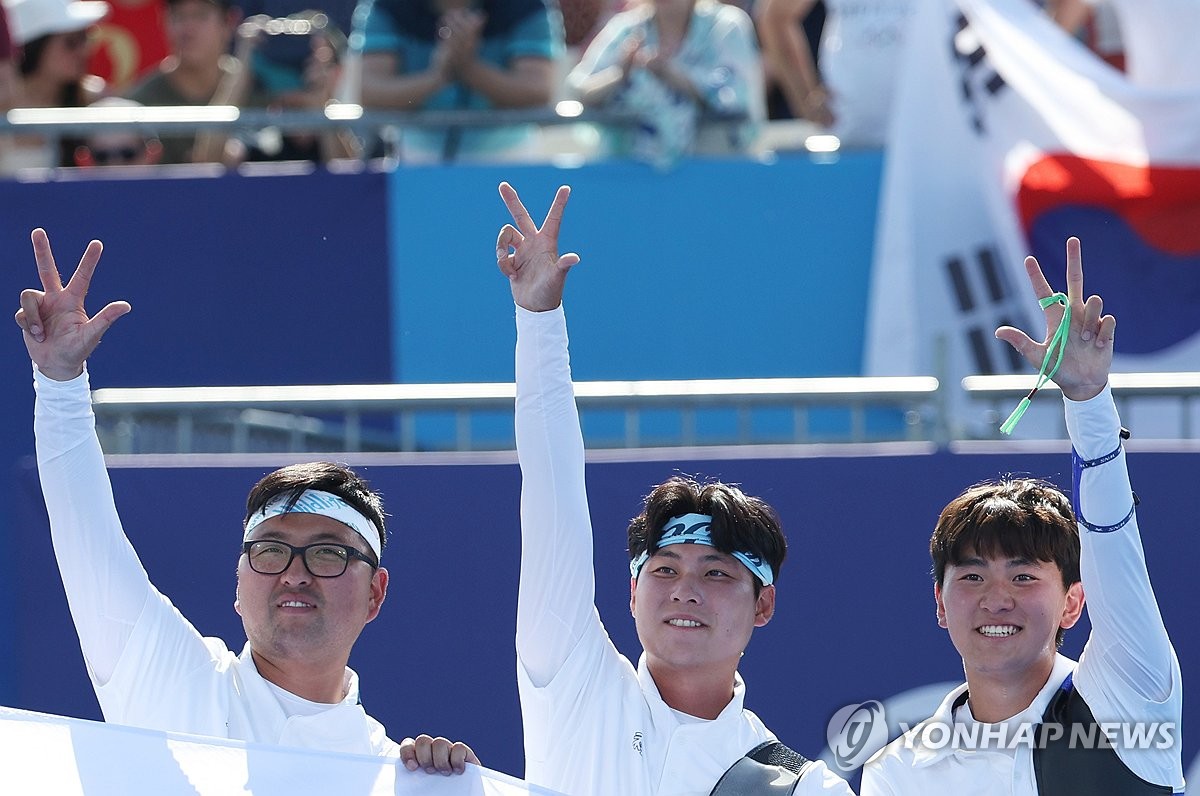 Kim Woo-jin. Lee Woo-seok and Kim Je-deok of South Korea (L to R) celebrate after winning the gold medal in the men's archery team event at the Paris Olympics at Invalides in Paris on July 29, 2024. They each raised three fingers to signify South Korea's third straight Olympic gold in that event. (Yonhap)