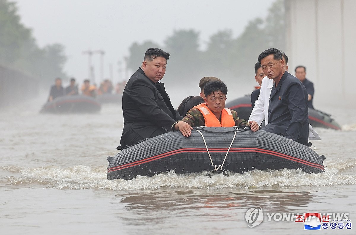 This photo, carried by North Korea's official Korean Central News Agency on July 31, 2024, shows the North's leader Kim Jong-un (L) aboard a boat to inspect flood-hit areas in North Korea's border city of Sinuiju. (For Use Only in the Republic of Korea. No Redistribution) (Yonhap)