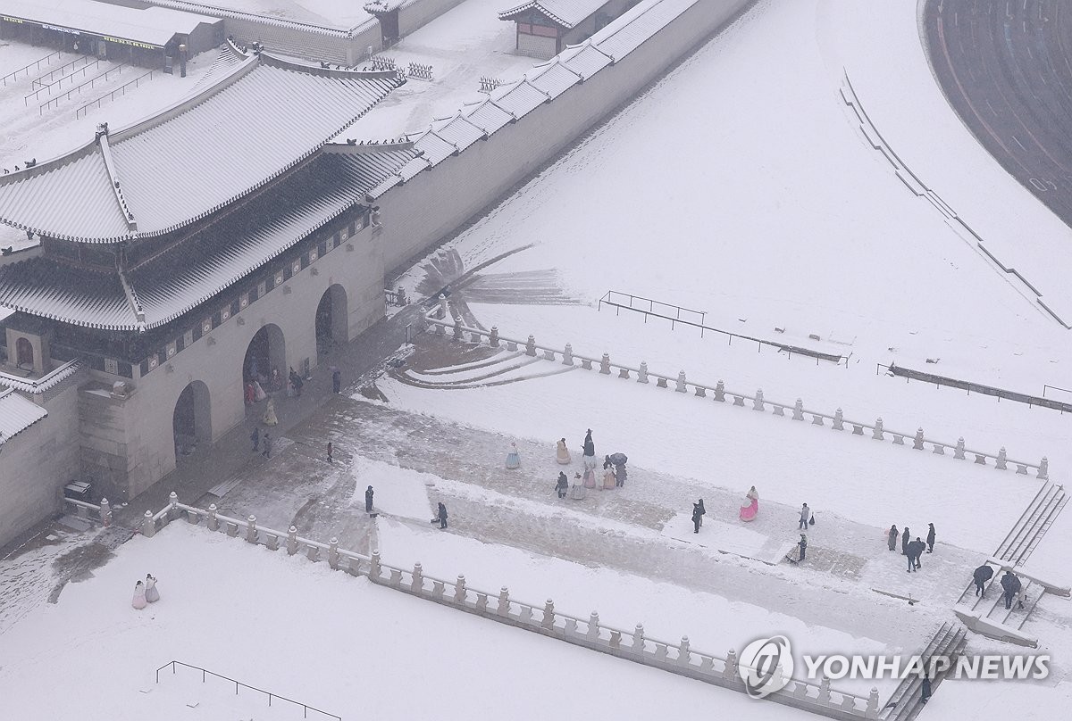 Funcionarios limpian la nieve en el Palacio Gyeongbok, en el centro de Seúl, el 5 de enero de 2025. (Yonhap)